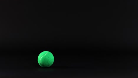 a tennis ball bounces in a dark space