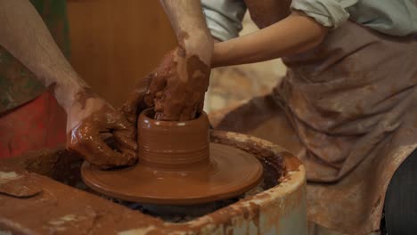 pottery classes, woman making clay pot on wheel. close-up of dirty hands, sculpting clay crockery masterclass pottery training