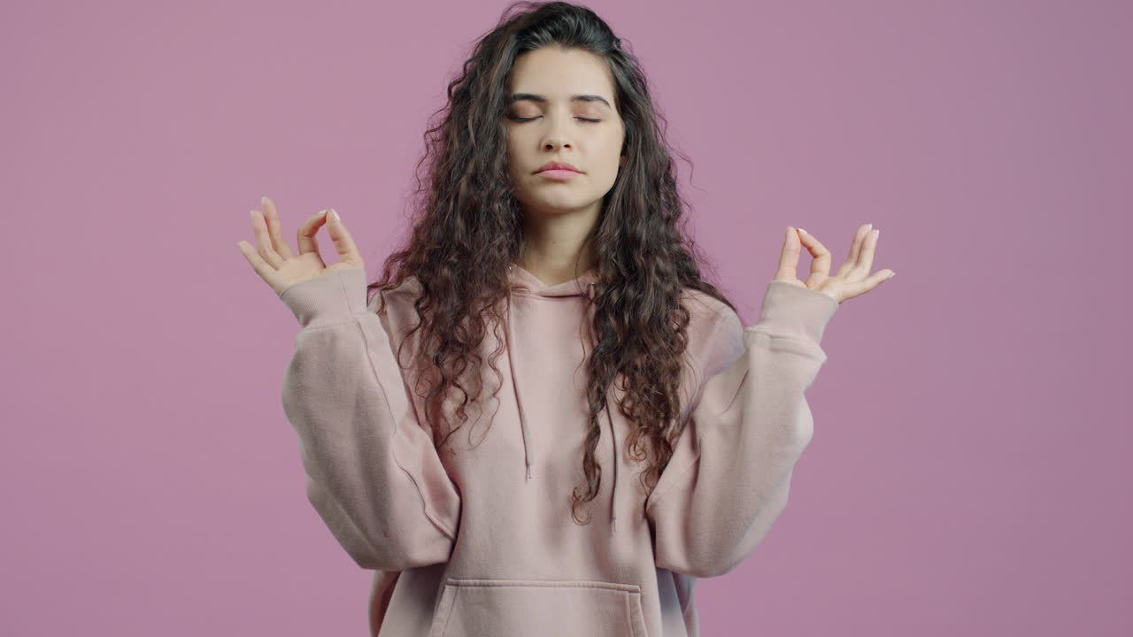 Woman Meditating in Pink Hoodie