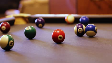 colorful billiard balls rolling on the pool table - close up