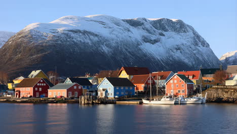 colorful village in a norwegian fjord with snow-capped mountains