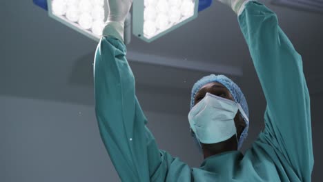 médica afroamericana con máscara facial en la sala de operaciones del hospital, cámara lenta