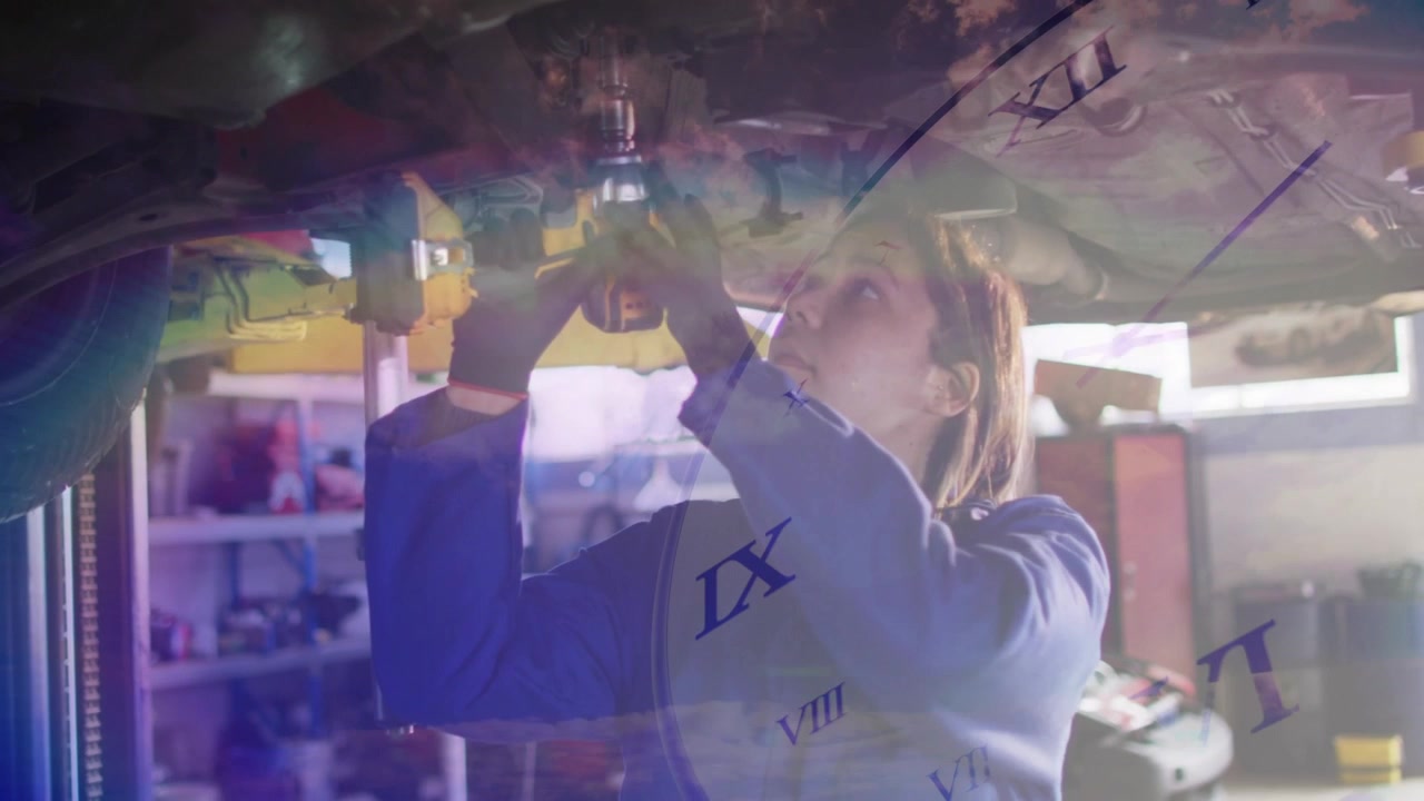 Auto tech using yellow drill under car torquing bolt to align, clock numerals rainbowband drifting