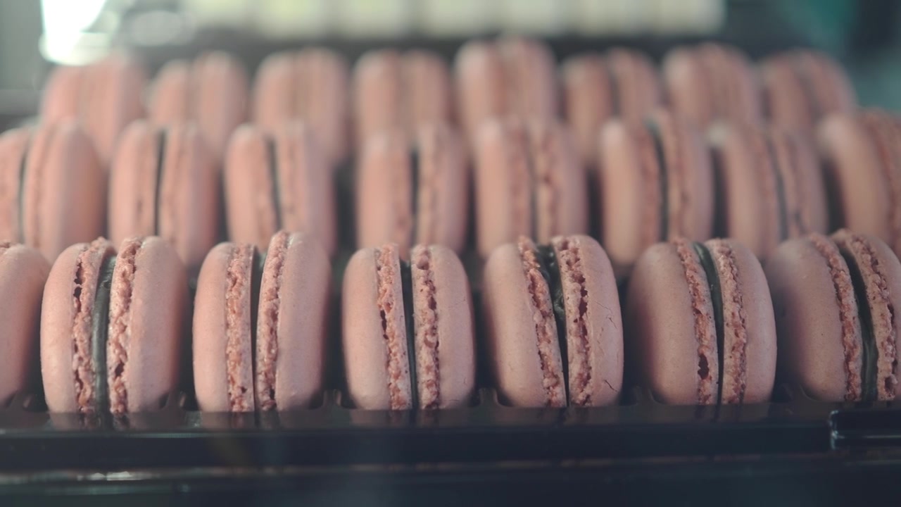 Rows of Freshly Baked Pink Macarons in a Display Case