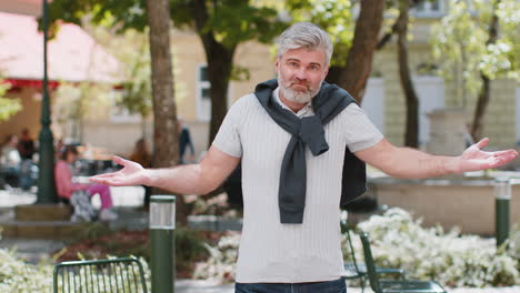 confused mature man having doubts no idea being clueless uncertain feeling embarrassed, city street