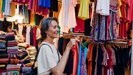woman shopping for colorful clothes at a market