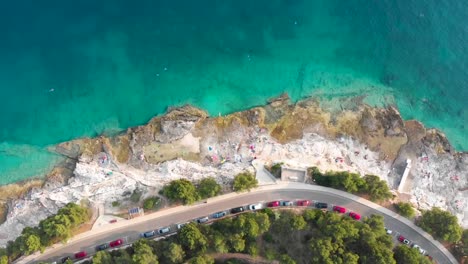 dron girando y descendiendo disparado sobre una playa rocosa