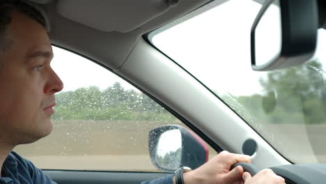 hombre conduciendo un coche en un día de lluvia