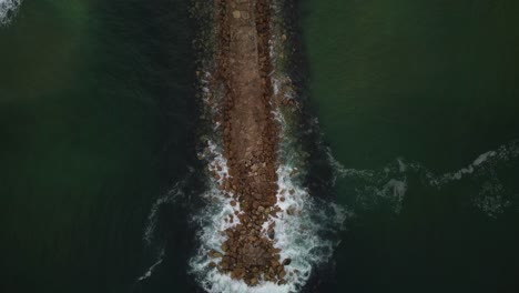 Breakwater-Jetty-on-Coast-of-Costa-da-Caparica,-Portugal---Aerial-Top-Down