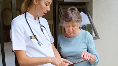 mujer mayor y médico discutiendo sobre una tableta digital 4k