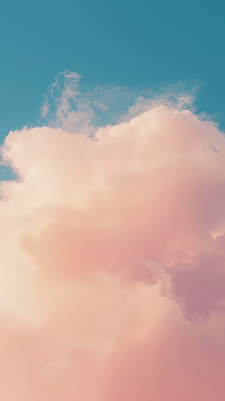 Vertical video: Drifting under light wind, large peach cumulus cloud thinning top wisps at sunrise