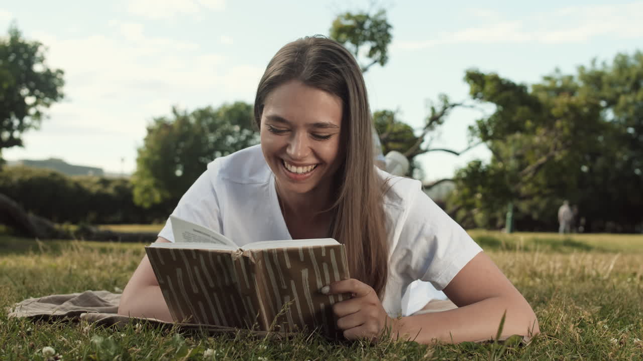 Woman Reading Book Lying on Lawn