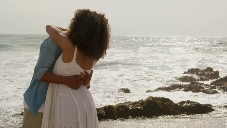 African american couple embracing each other on the beach 4k