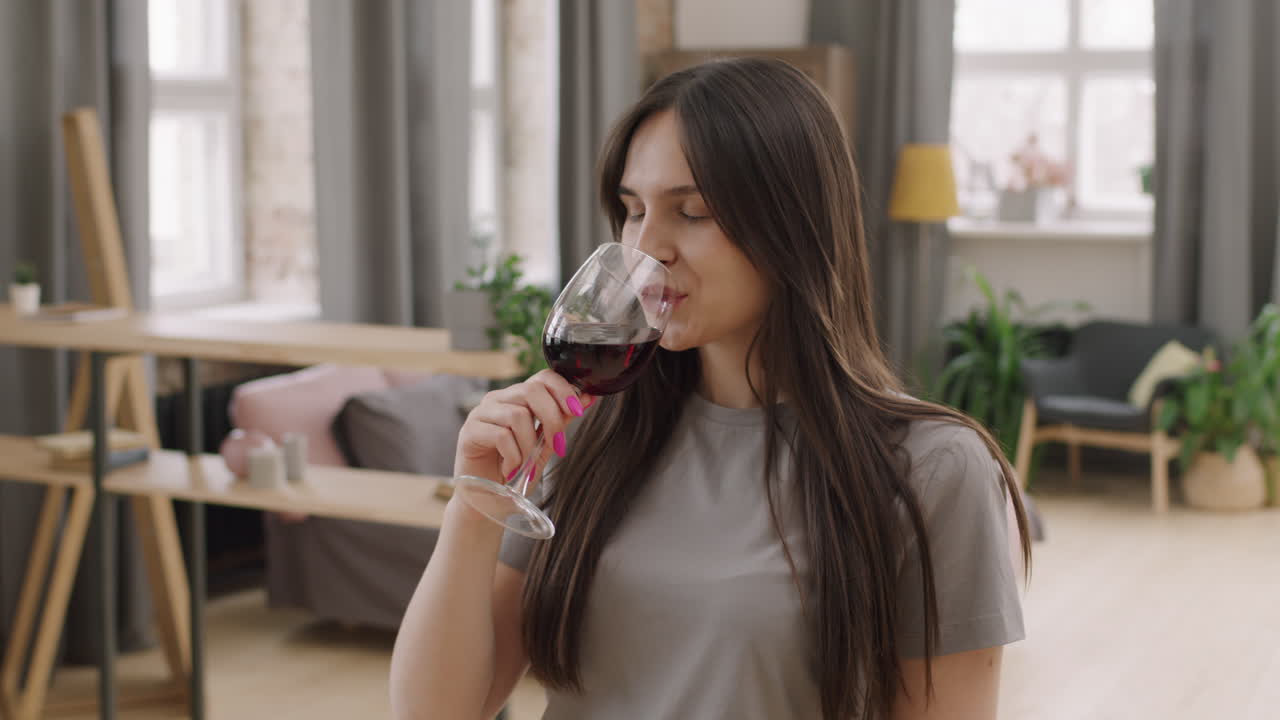 Happy Woman Enjoying Wine and Dancing at Home