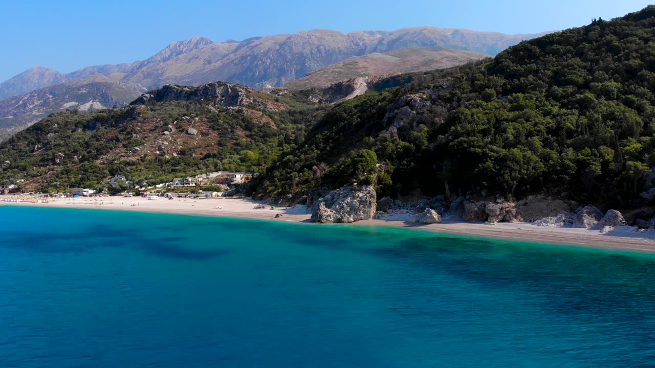 Tranquil beach with no people on a remote shoreline with sand washed by blue azure sea water in Albania