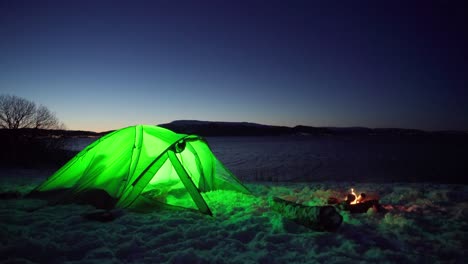 Tienda-De-Campaña-Verde-Iluminada-Con-Fuego-De-Campamento-Por-La-Noche