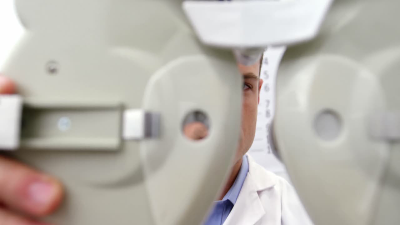 Attentive optometrist adjusting phoropter