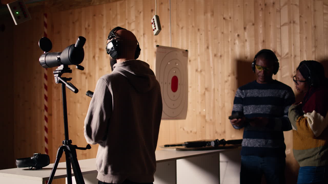 총기 연습 중 확대 렌즈를 사용하여 총에 맞은 표적을 분석하는 사람