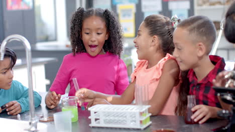 in school, diverse group of young students enjoying a chemistry experiment