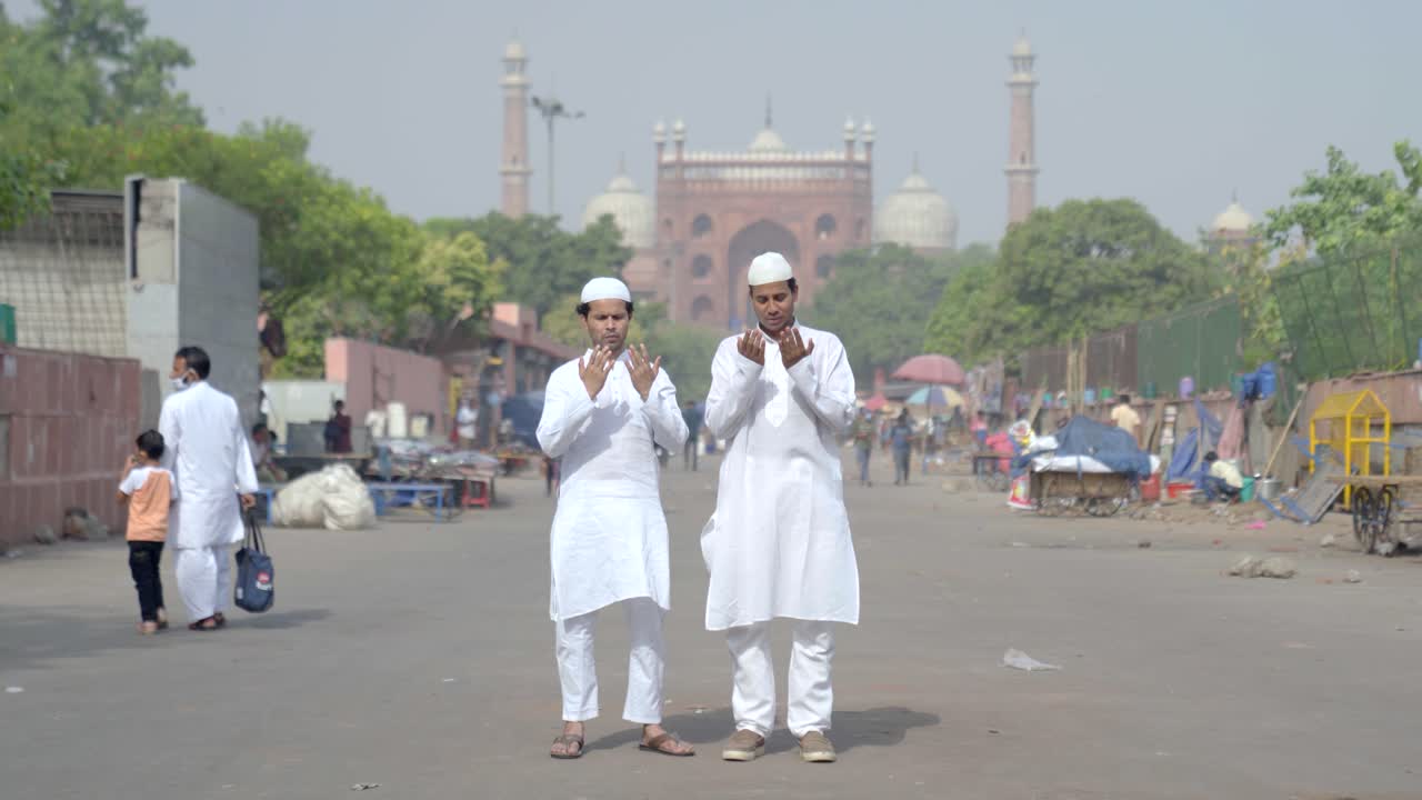 Müslüman erkekler Hindistan Delhi'deki Cuma Camii önünde namaz kılıyor.