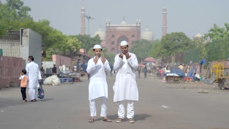 muslim men praying in front of a jama masjid delhi india