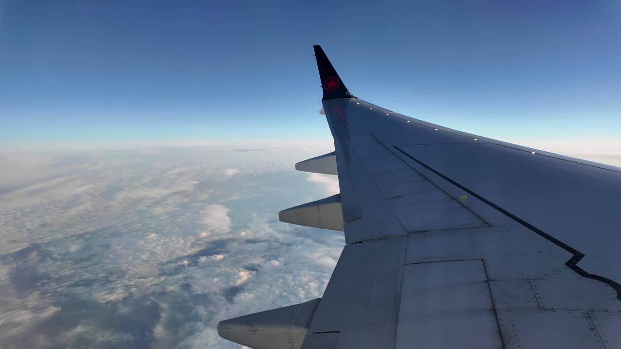 Aerial view from airplane window showing clouds and Atlantic Ocean during Air Canada flight, capturing the vast expanse of water below