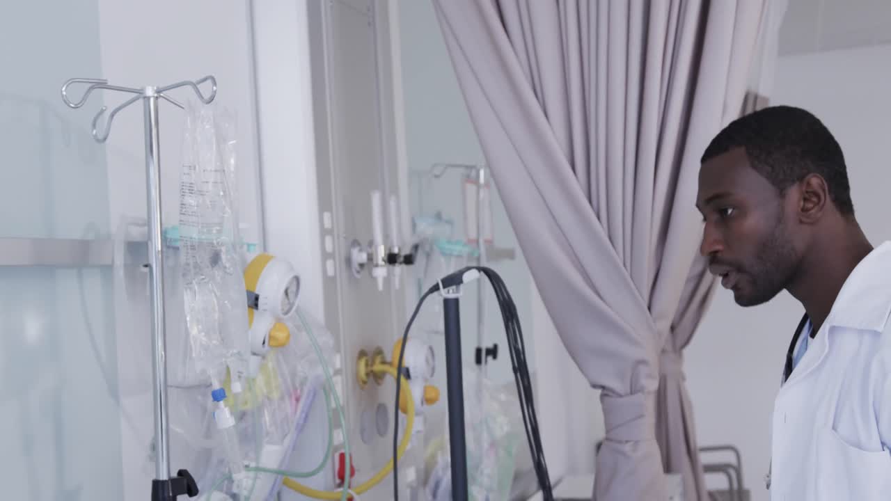 Medico afroamericano che controlla una flebo in camera d'ospedale, al rallentatore