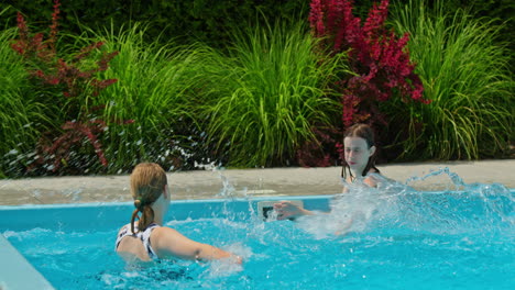 madre e hija divirtiéndose salpicando en una piscina