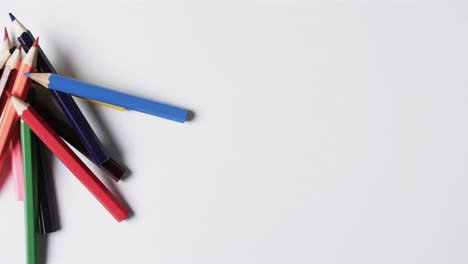 overhead view of crayons on white background, in slow motion