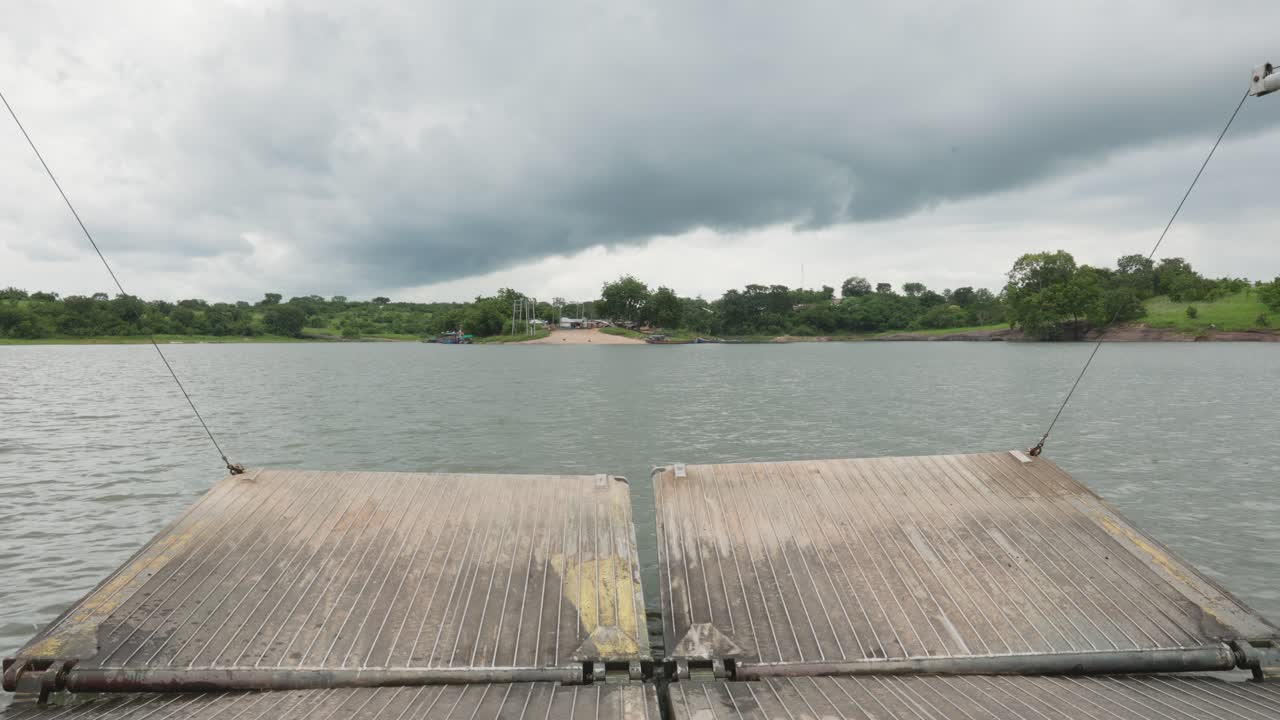 여행하는 바지선은 흐린 날에 잔잔한 강에서 섬에 접근합니다.