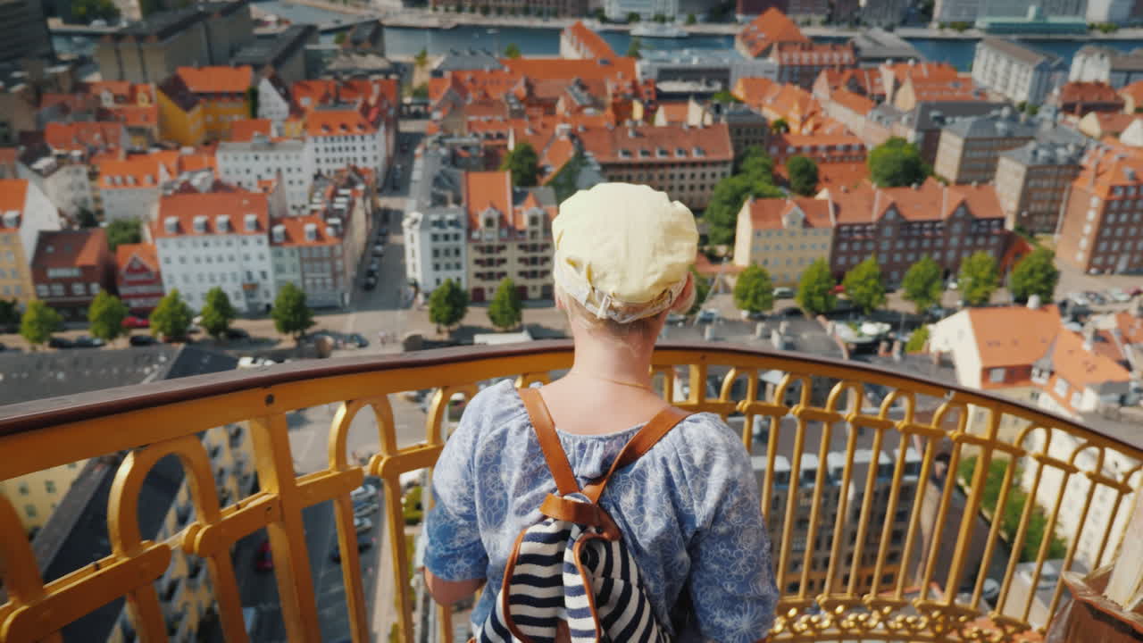 un turista con una mochila y la bandera de dinamarca sube por la famosa escalera de caracol de la iglesia