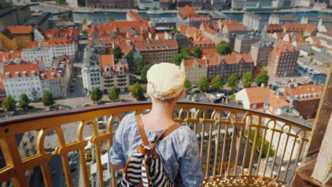 a tourist with a backpack and the flag of denmark rises up the famous spiral staircase of the church