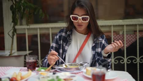 young woman eating breakfast outdoors