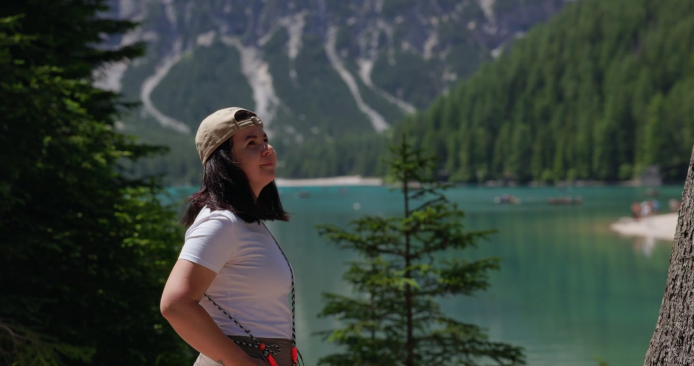 Woman Enjoying The View of Lago Di Braies (Pragser Wildsee) In South Tyrol, Italy, Within The Prags Dolomites. - wide shot