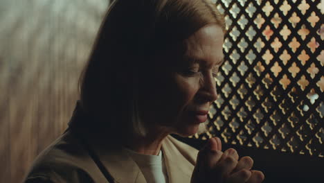 Female Parishioner Praying during Confession in Church