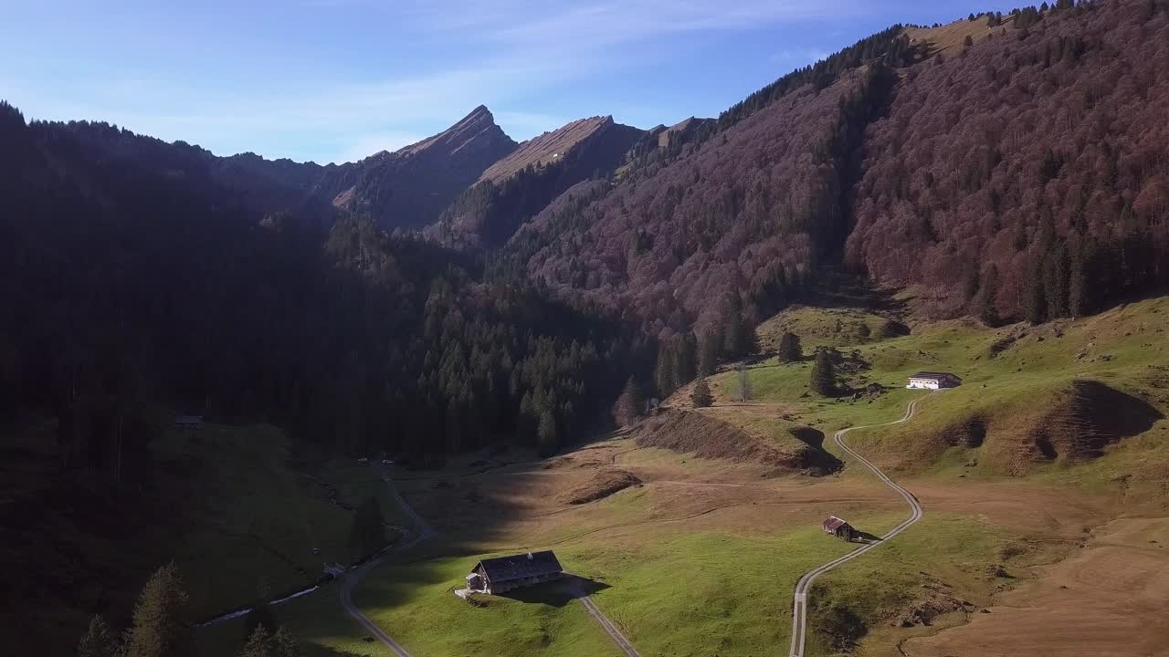 varias cabañas pequeñas ubicadas debajo del pico de speer, rodeadas de majestuosos colores de otoño, antena establecer