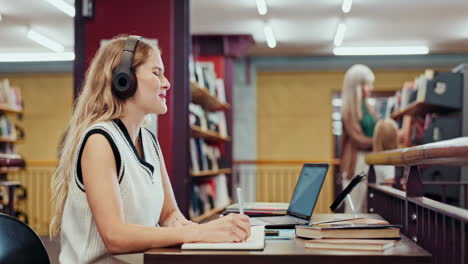 woman studying in a library with family in the background