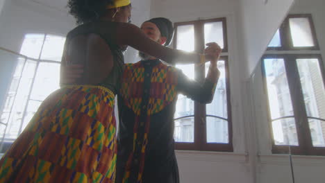 graceful couple performing sensual tango dance in sunlit studio