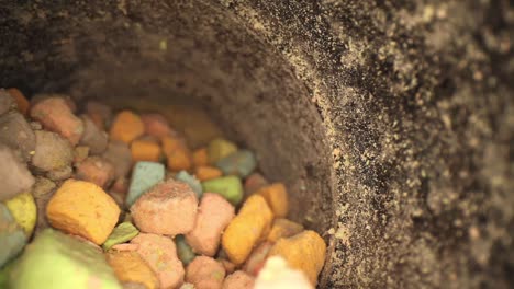 Pulling-out-of-bottom-of-container-of-multi-colored-marshmallow-pieces