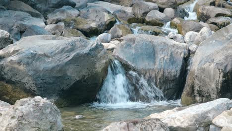 a mountain river stream flows gracefully over rocks and stones, weesen, st. gallen, near lake walensee, switzerland.