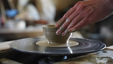 Artisan&#039;s hands expertly shaping clay on a pottery wheel