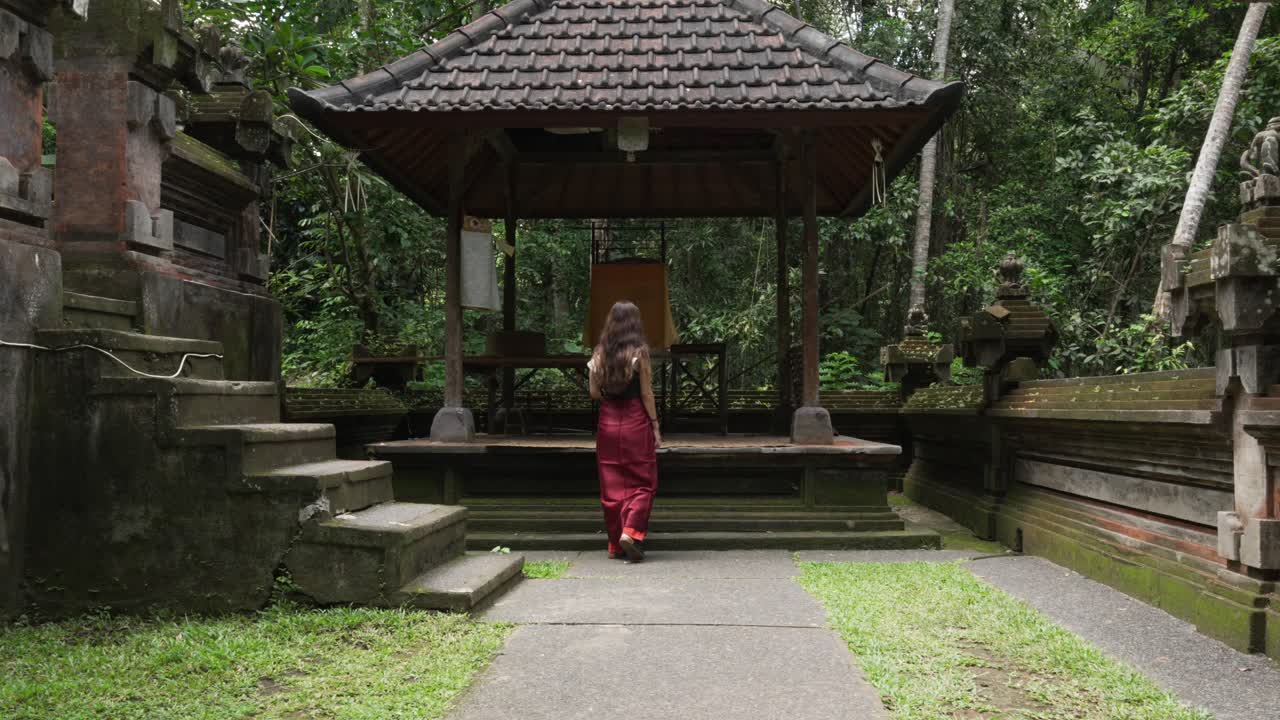 Young beautiful woman dressed in Balinese dress at Goa Gajah temple Bali Indonesia