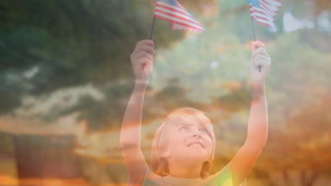 child holding out american flags and the sky