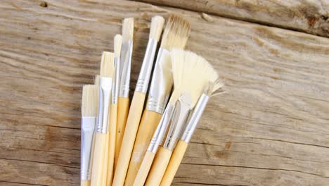 Various-paint-brushes-on-wooden-table