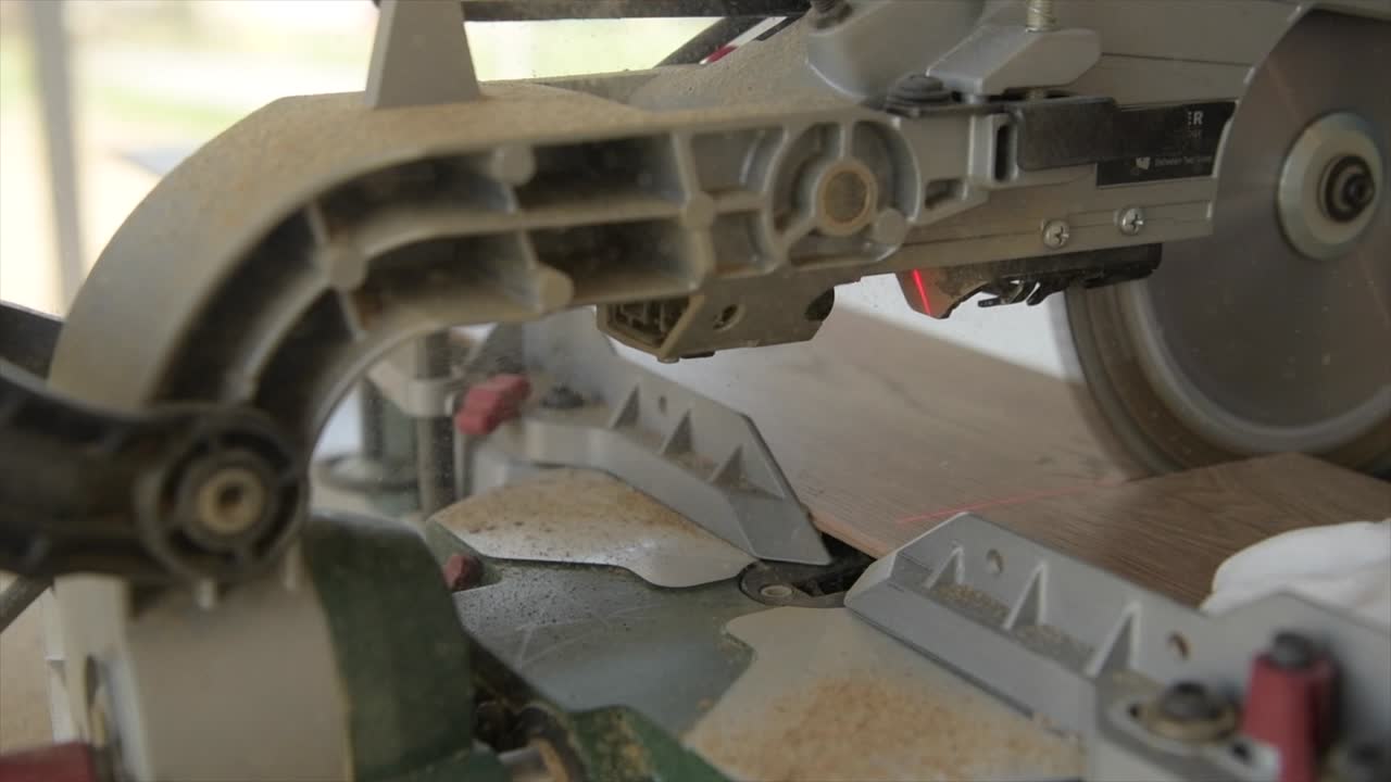 원형 도끼를 사용하여 나무 바닥 패널을 절단하는 느린 동작 영상.