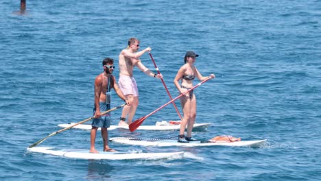 turistas que hacen paddle boarding en sorrento, nápoles, italia