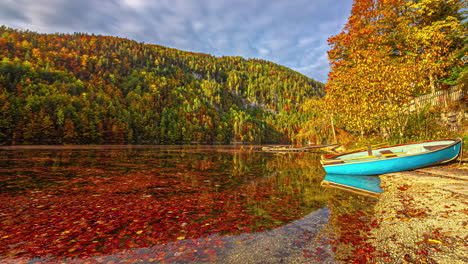 timelapse of a boat at a lake, colorful autumn foliage in the alps of austria