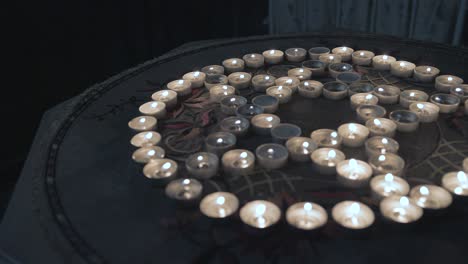 candle lit pentagram on table inside creepy dark bedroom. follow shot