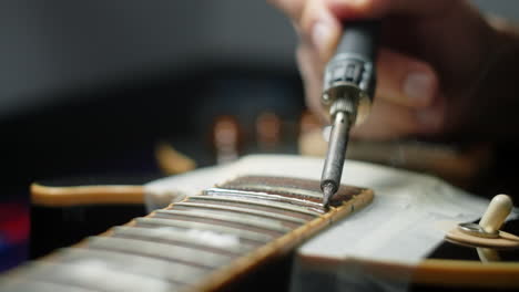 guitar repair technician soldering guitar neck