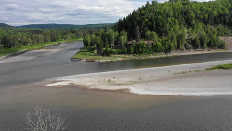 High-Tree-Top-Fly-Over-Reveal-Footage-overlooking-dry-river-bed-at-Restigouche-River,-New-Brunswick,-Canada